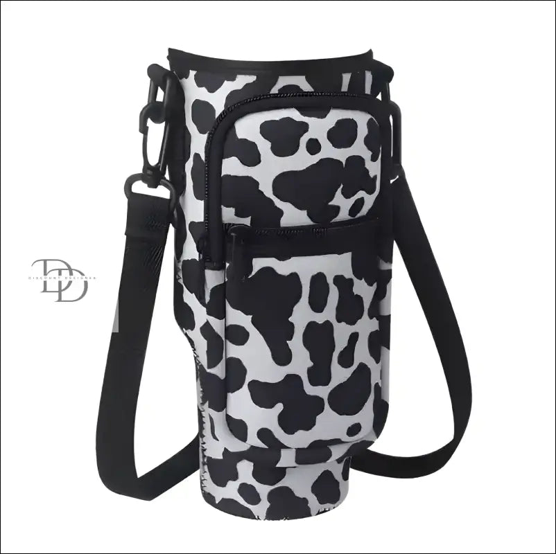 Insulated drink holder with a cow print pattern and shoulder strap.