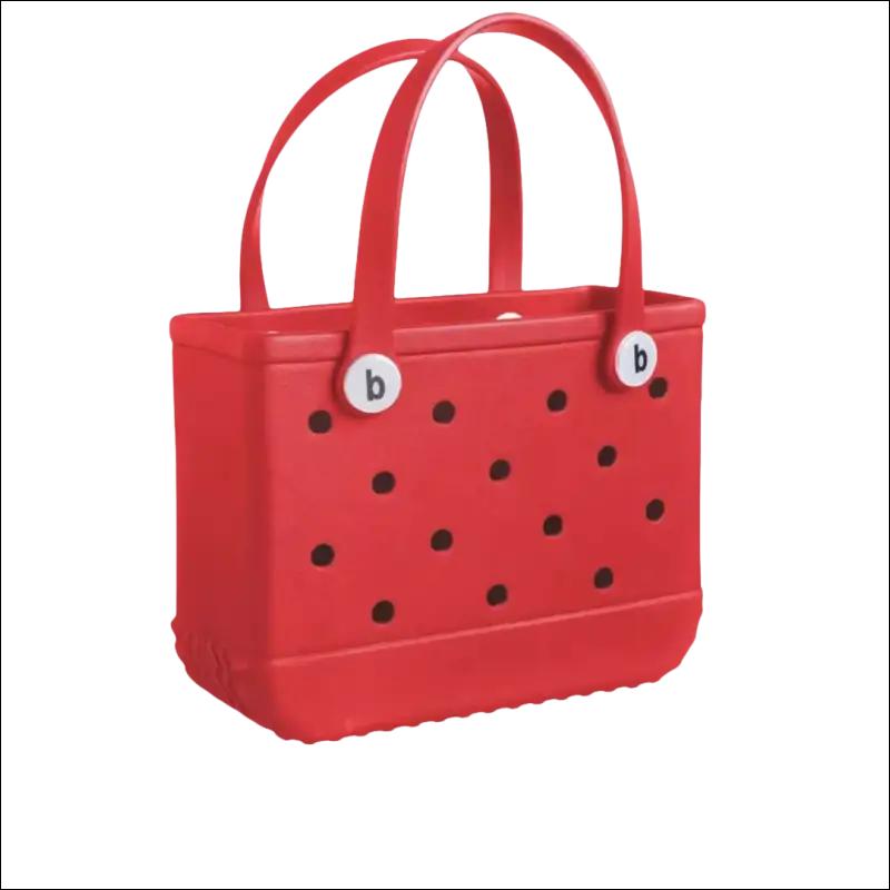 Red handbag with black polka dots and dual handles.